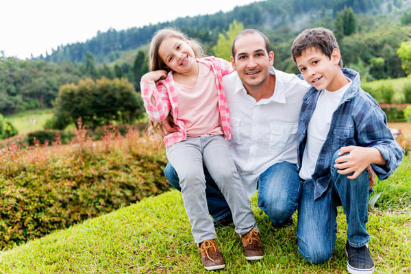 Happy father enjoying with his kids outdoors and smiling