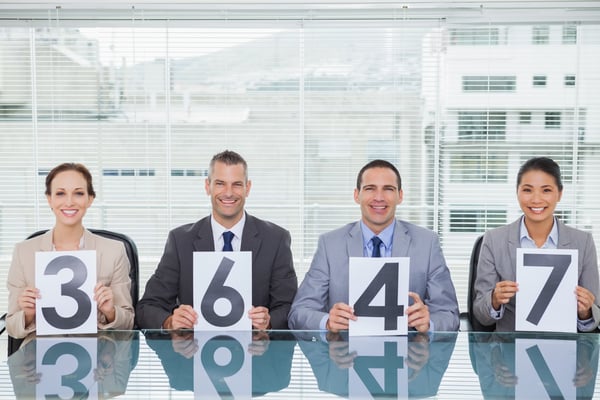 Smiling interview panel holding papers giving grade to their applicant in bright office